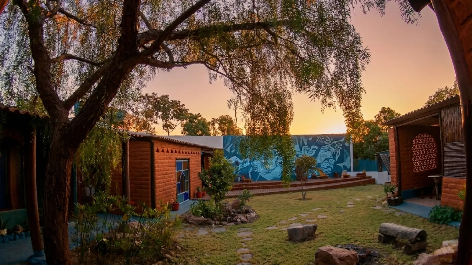 Visão interna do pátio e das construções da Shanti Pousada ao entardecer